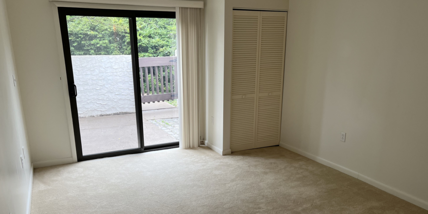 an empty room with sliding glass doors leading to a balcony