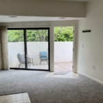 an empty room with sliding glass doors leading to a patio