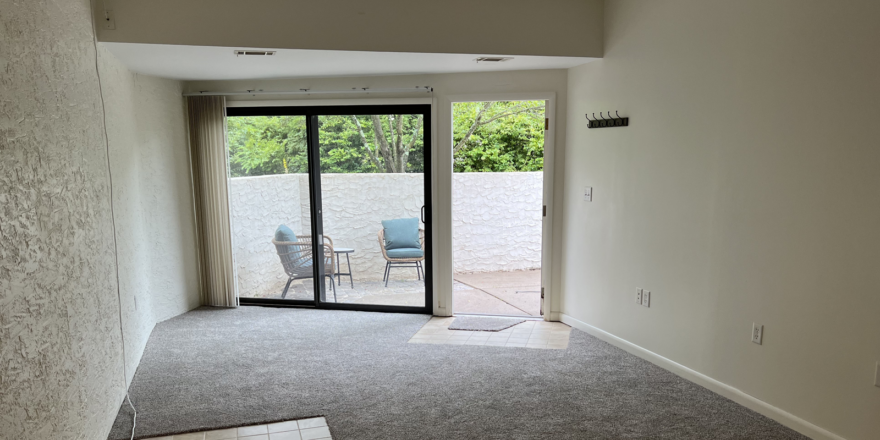 an empty room with sliding glass doors leading to a patio