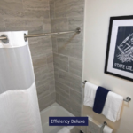 a bathroom with a white shower curtain and blue and white towels