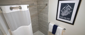a bathroom with a white shower curtain and blue and white towels