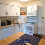 a kitchen with white cabinets and a wooden table