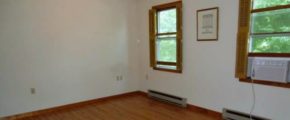 Unfurnished bedroom with window AC unit, ceiling fan, and hardwood floors