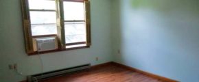 Unfurnished bedroom with window AC unit, ceiling fan, and hardwood floors