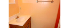 Half-bathroom with toilet, vanity, and mirror