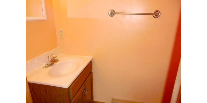 Half-bathroom with toilet, vanity, and mirror