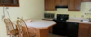 Kitchen with barstool seating, appliances, and cabinets