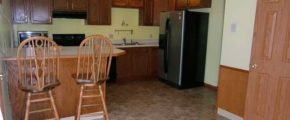 Kitchen with barstool seating, appliances, and cabinets