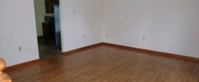 Unfurnished living room with open doorway into kitchen