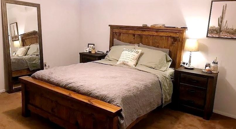 Bedroom with large bed, large mirror, and two end tables