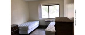 Bedroom with LVT flooring, 2 beds, 2 dressers, window, and AC unit