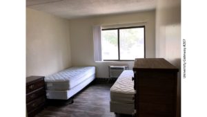 Bedroom with LVT flooring, 2 beds, 2 dressers, window, and AC unit