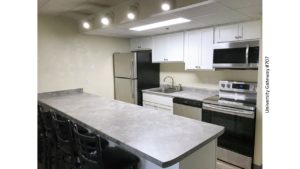 Kitchen with white cabinets, light gray countertops, barstool seating, and stainless steel appliances