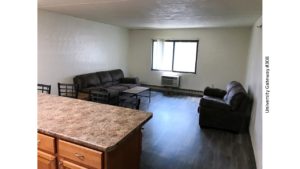 Living room with LVT flooring, end table, coffee table, window, AC unit, loveseat, and sofa