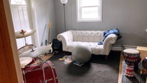 Room with couch, drum set and other instruments