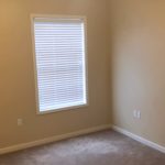 Unfurnished, carpeted bedroom with window