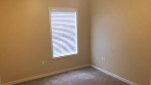 Unfurnished, carpeted bedroom with window