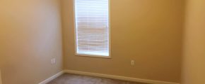 Unfurnished, carpeted bedroom with window