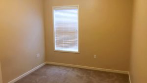 Unfurnished, carpeted bedroom with window