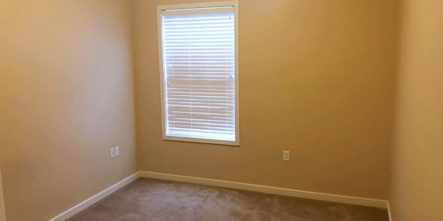 Unfurnished, carpeted bedroom with window