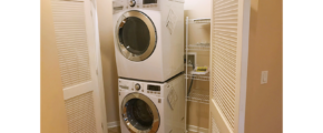 Laundry closet with stacked washer and dryer and wire shelving