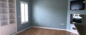 Unfurnished living room with built-in shelving, fireplace, and TV