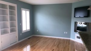 Unfurnished living room with built-in shelving, fireplace, and TV