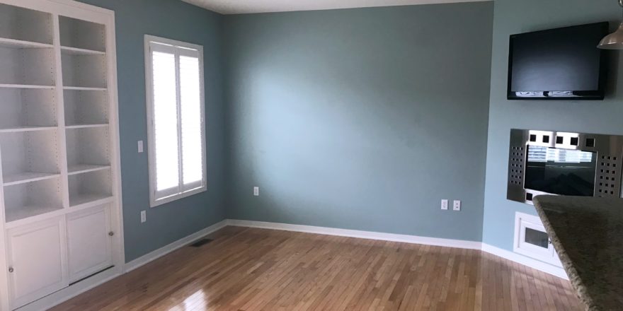 Unfurnished living room with built-in shelving, fireplace, and TV