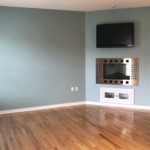 Unfurnished living room with built-in shelving, fireplace, and TV