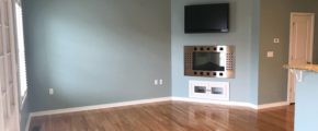 Unfurnished living room with built-in shelving, fireplace, and TV