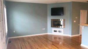 Unfurnished living room with built-in shelving, fireplace, and TV