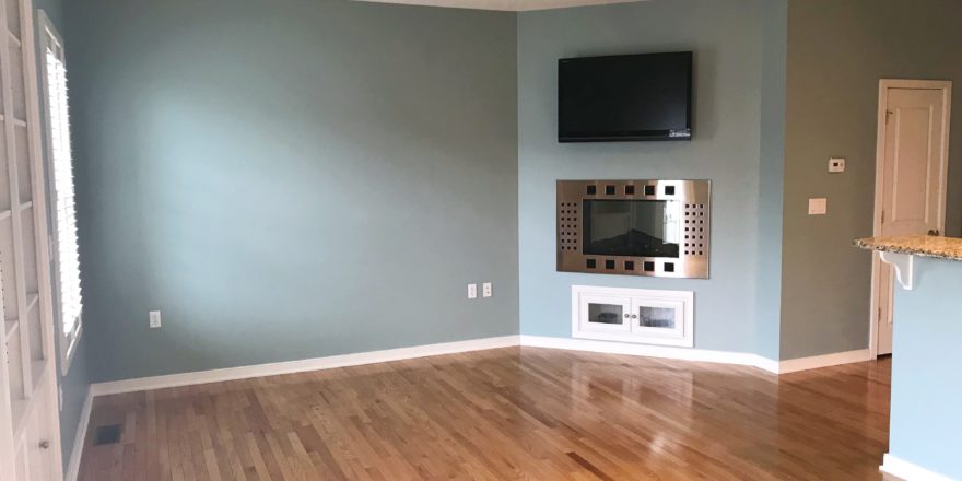 Unfurnished living room with built-in shelving, fireplace, and TV