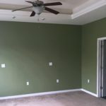 Unfurnished, carpeted owner's suite bedroom with ceiling fan