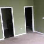 Unfurnished, carpeted owner's suite bedroom viewing into en suite bathroom and walk in closet