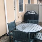 Fenced-in patio with furniture and grill