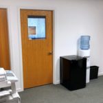Office space with copy machine, small fridge, and water cooler