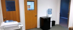 Office space with copy machine, small fridge, and water cooler