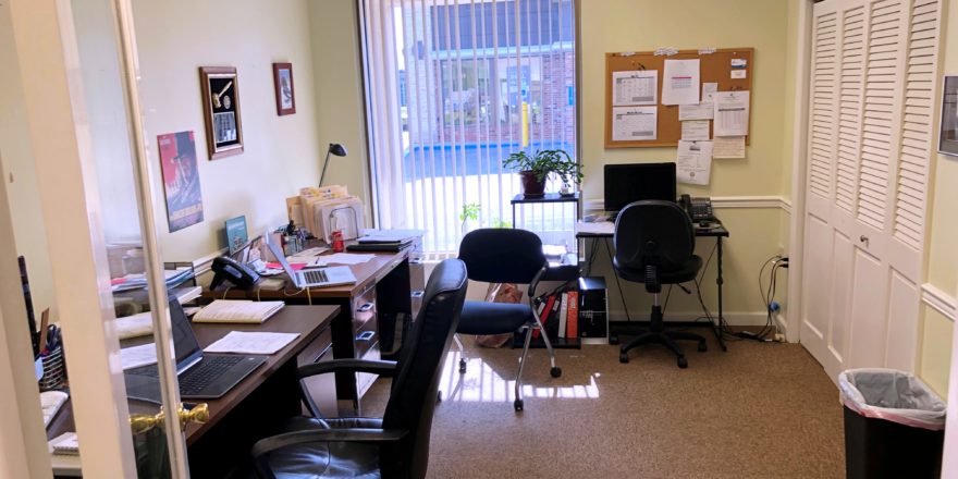 Office with three desks, chairs, a closet, and large window