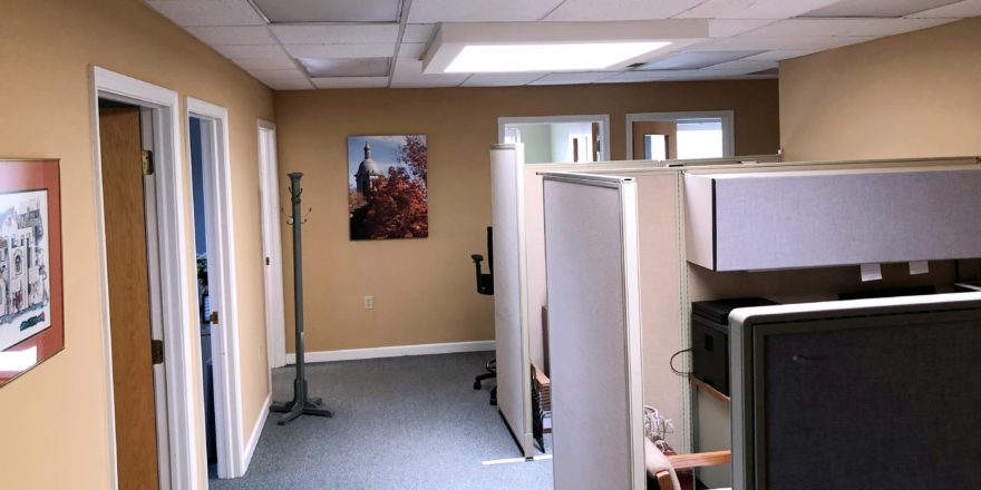 Office space area with cubicles and coat rack