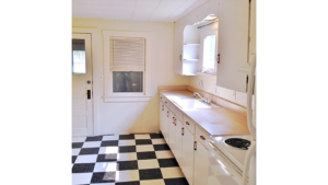 Kitchen with tile floors, white cabinets, and white appliances