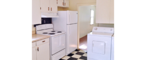 Kitchen with tile floors, white cabinets, and white appliances