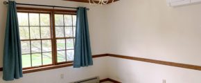 Carpeted dining area with window and chandelier