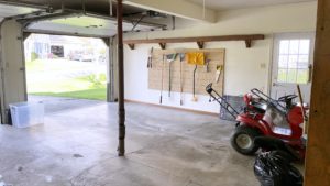 Garage with shelving and gardening equipment