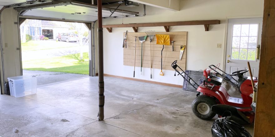 Garage with shelving and gardening equipment