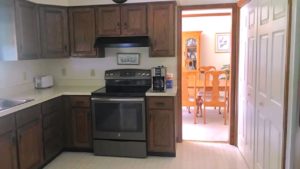 Kitchen with laundry closet, cabinets, and appliances
