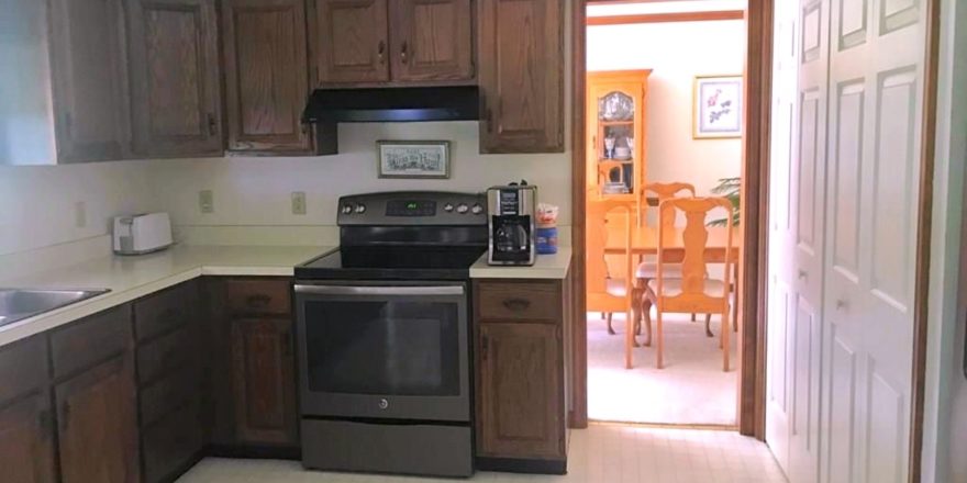 Kitchen with laundry closet, cabinets, and appliances