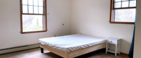 Bedroom with windows, bed, and nightstand