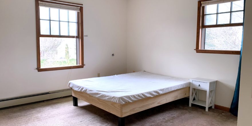 Bedroom with windows, bed, and nightstand