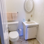 Half bathroom with toilet, vanity, and mirror