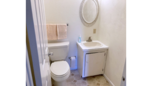 Half bathroom with toilet, vanity, and mirror